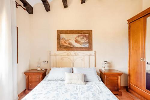 Vinyols i els ArcsMasia Castellvi的一间卧室配有白色床和2个床头柜