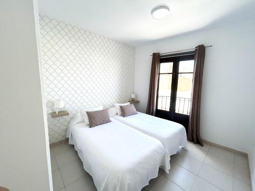 阿雷西费Mahostly Apartamento Comillas PB的一间白色卧室,配有两张床和窗户