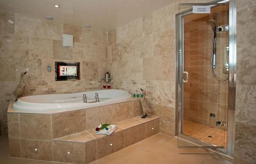 鲍内斯温德米尔Aphrodites Group的大型浴室设有浴缸和淋浴。