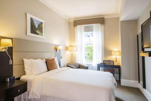 波士顿纽伯里宾馆的酒店客房设有白色的床和窗户。