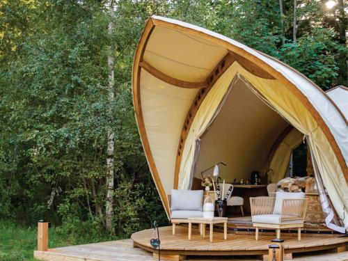 马赛马拉Hotel Lion Sands Masai Mara Lodge的木制甲板上配有两把椅子的帐篷