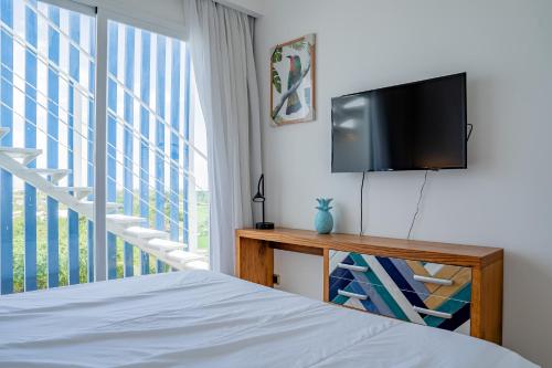 蓬塔卡纳Xeliter Cana Rock Punta Cana的一间卧室配有一张床和一台平面电视