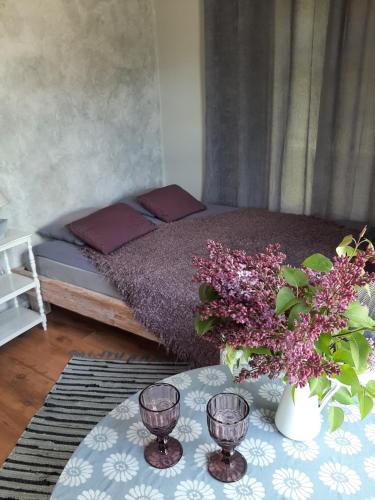 TuraidaMellene 1 bedroom house in nature & hot tube的一间卧室配有一张床和一张鲜花桌