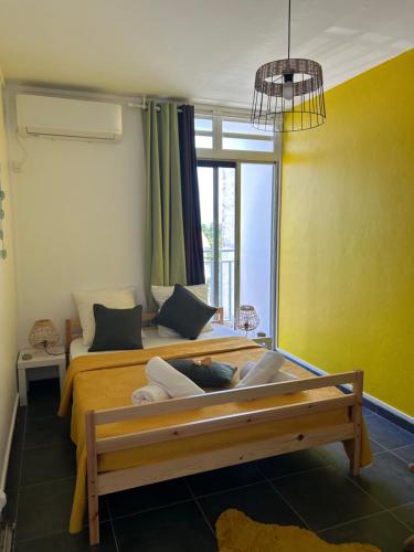 皮特尔角城Appartement avec vue panoramique de Pointe-à-Pitre的一间卧室配有一张床、一张沙发和一个窗口