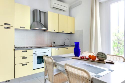 加比切马莱Residence Diffuso Arcobaleno的厨房配有白色橱柜和桌椅