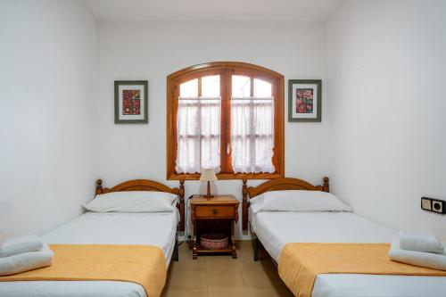 拉梅特拉·德·玛尔Dúplex con encanto的客房设有两张单人床和一扇窗户。