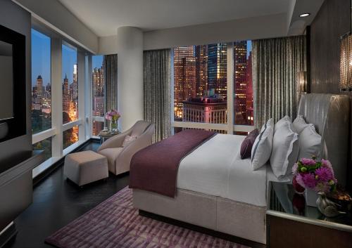 纽约Mandarin Oriental, New York的一间卧室设有一张大床和一个大窗户