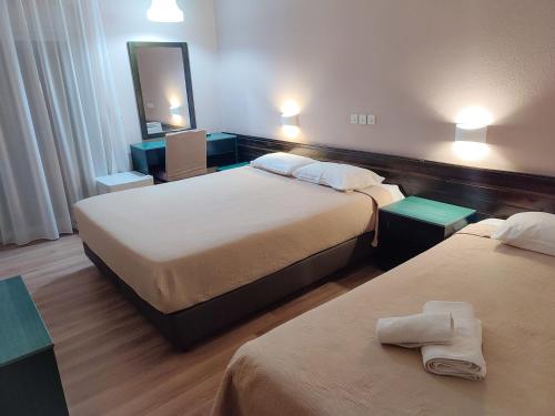 亚历山德鲁波利斯Plaza Hotel的酒店客房,设有两张床和镜子