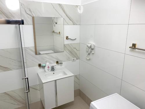 维利波吉Fishta Apartment Q6 37的白色的浴室设有水槽和镜子