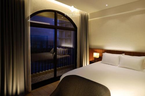 Dahan春沐七星潭海岸旅店的一间卧室设有一张床和一个大窗户