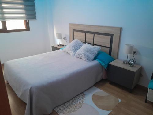 蒙特罗伊IM80的卧室配有带蓝色枕头的大型白色床