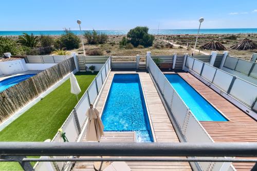 萨贡托Casa frente al mar con piscina privada的背景海滩的游泳池