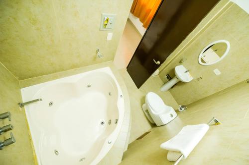 普卡尔帕Hotel Luxor Pucallpa的带浴缸、卫生间和镜子的浴室