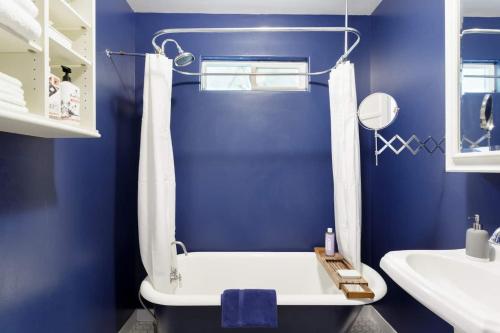 洛杉矶Silver Lake Mid-century Nestled In The Treetops的蓝色的浴室设有浴缸和水槽