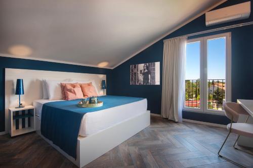 普拉Vinkuran Residence - Adults Only的蓝色和白色的卧室设有床和窗户