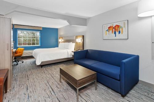 卡梅尔Holiday Inn Express & Suites Carmel North – Westfield, an IHG Hotel的酒店客房,配有床和蓝色的沙发