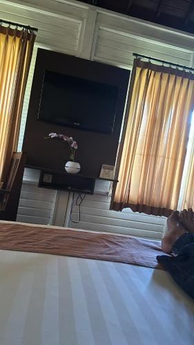 金巴兰Balangan Surf Resort的躺在床上的平面电视