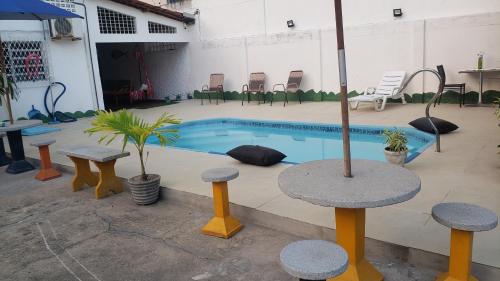 若昂佩索阿Pousada e Hostel sol e mar的大楼内带桌椅的游泳池