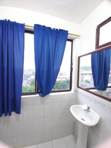 蒙塔尼塔MONTANITA Hugos Place的一间带水槽和蓝色窗帘的浴室