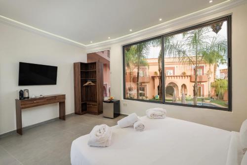 马拉喀什Albakech Boutique Hôtel & Spa的卧室设有2张白色的床和大窗户