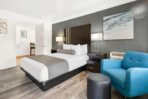 蒙特雷蒙特雷贝斯特韦斯特科瑞斯特公园酒店的酒店客房,配有一张床和一张蓝色椅子