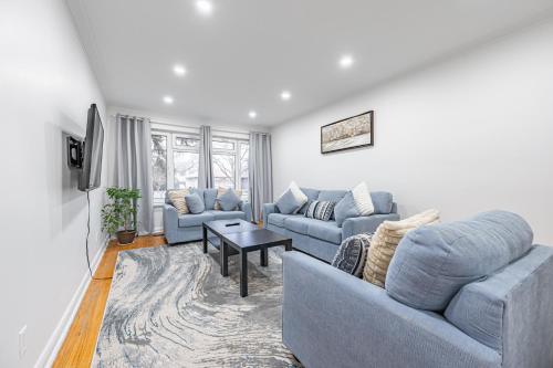 多伦多Littlewood Properties的客厅配有2张蓝色的沙发和1张桌子