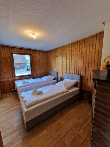 温特巴赫RANGE- Landhaus mit Panoramablick - 2 Apartments - 12 Personen的木墙客房的两张床
