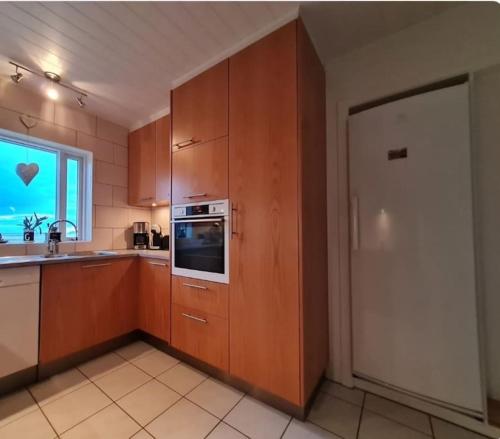 瑟伊藻克罗屈尔Ibúð með einstöku útsýni的厨房配有木制橱柜、水槽和微波炉