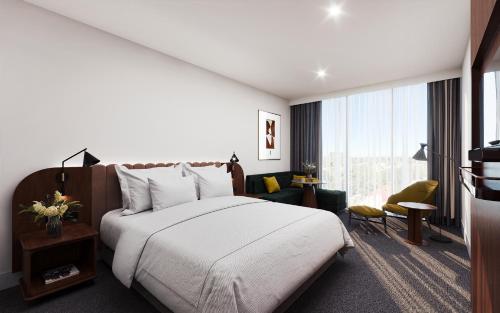 阿德莱德Crowne Plaza Adelaide Mawson Lakes, an IHG Hotel的酒店客房设有一张床和一个大窗户