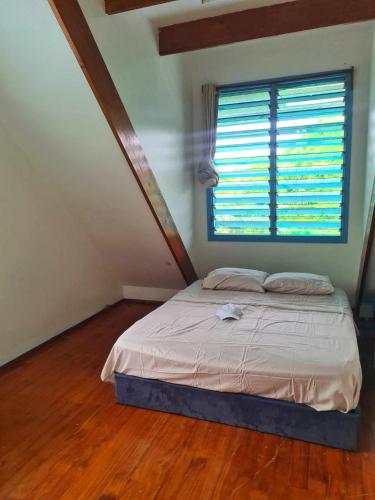 阿皮亚USO Homestay Samoa的一间卧室,在阁楼上设有床和窗户