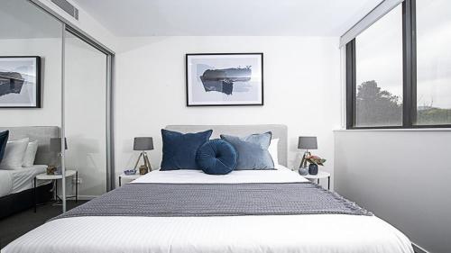 CampbellCanberra Chic I30的一间卧室配有一张带蓝色枕头的大床
