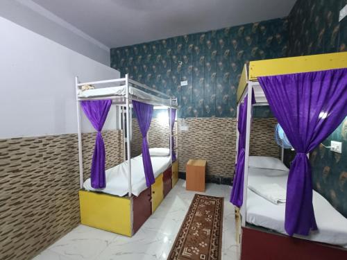 瓦拉纳西Mohit Paying Guest house的一间卧室配有两张双层床和紫色窗帘
