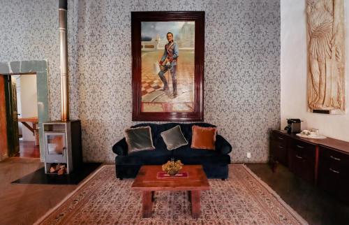 雷亚尔卡托尔塞Casa Grande - Adults Only的客厅配有蓝色沙发和绘画作品