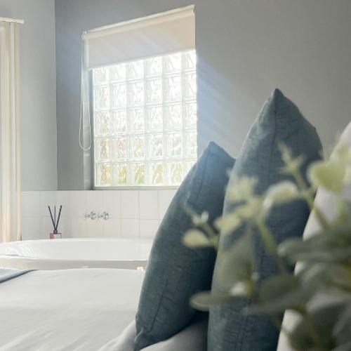 坎贝尔港波浪豪华套房酒店的客房配有蓝色枕头、窗户和浴缸。