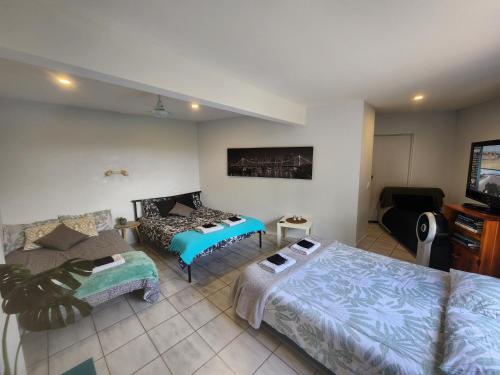 黄金海岸Self Contained Guesthouse for 7ppl, w Pool的客厅配有两张床和一台平面电视