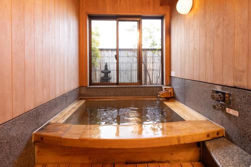 东京浅草指月日式旅馆的一个带窗户的客房内的按摩浴缸