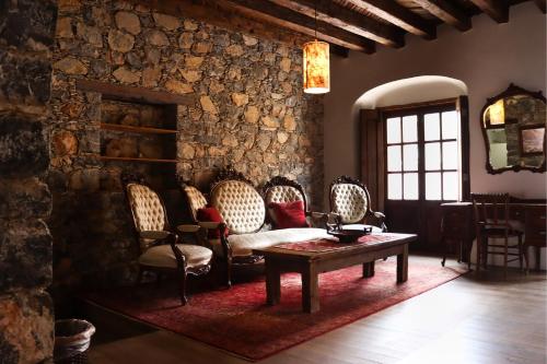 雷亚尔卡托尔塞Mesón de la Abundacia的客厅配有桌椅和石墙