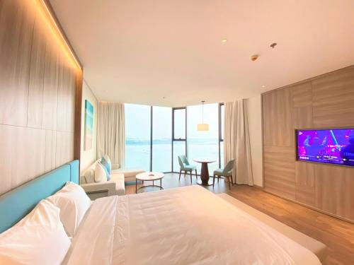 下龙湾Khách sạn A LaCarte Hạ Long - Quảng Ninh的配有一张床和一台平面电视的酒店客房
