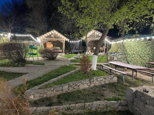 TaūtürgenКомплекс Тимур的夜间带长凳和野餐桌的公园