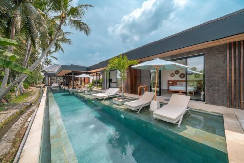 乌布Villa Surga - 4BR Heavenly Ricefields View Villa in Ubud的一个带躺椅的游泳池以及一座房子