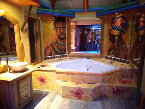 金特罗Hotel Boutique El Duende Mantagua的浴室配有壁画和浴缸