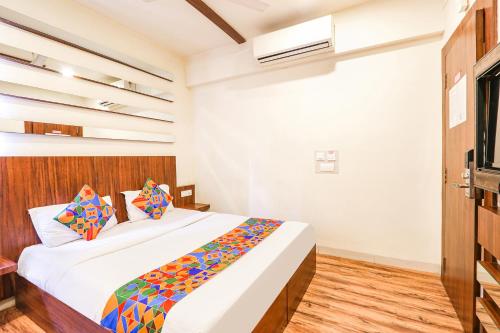 海得拉巴FabHotel Arastu的一间卧室配有一张带色彩缤纷枕头的大床