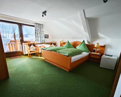 蒂蒂湖-新城菲德贝格布里克咖啡厅-潘森酒店的一间卧室配有一张带绿色枕头的床。