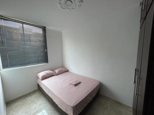 库库塔Bello apartamento de 3 habitaciones的一间小卧室,配有一张带粉色床单的床和窗户