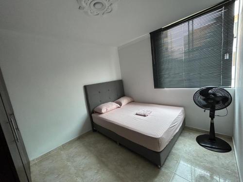 库库塔Bello apartamento de 3 habitaciones的一间带一张床和风扇的小卧室