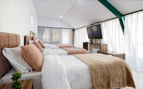 戈斯蒂瓦尔吉利绿色中心酒店的一间卧室配有两张床和电视。