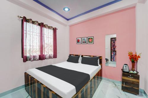 BihtaOYO Flagship R K Marriage Hall and Guest House的一间卧室配有一张床和粉红色的墙壁