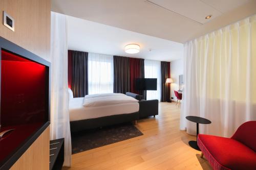 吕贝克IntercityHotel Lübeck的配有一张床和一台平面电视的酒店客房
