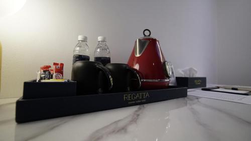 古晋Best Stay at Kozi Square的一个带茶壶和2瓶水的托盘