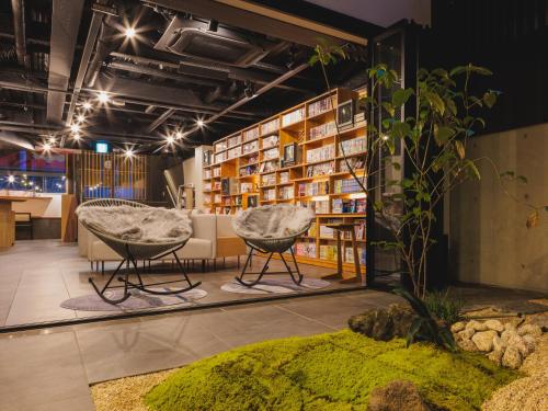 京都Giappo Franca Kyoto的一间设有两把椅子和书架的房间